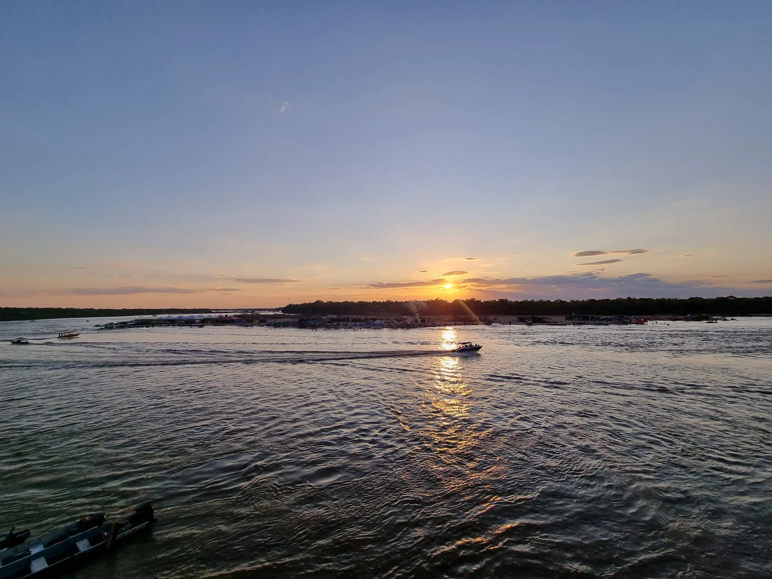 Pôr do sol sobre o rio Araguaia com um barco ao longe