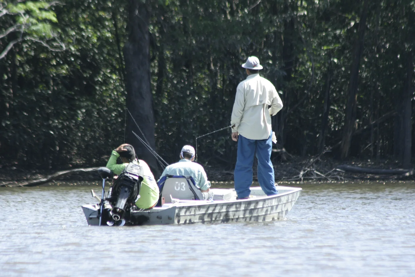 Três pescadores numa voadeira pescando no igapó